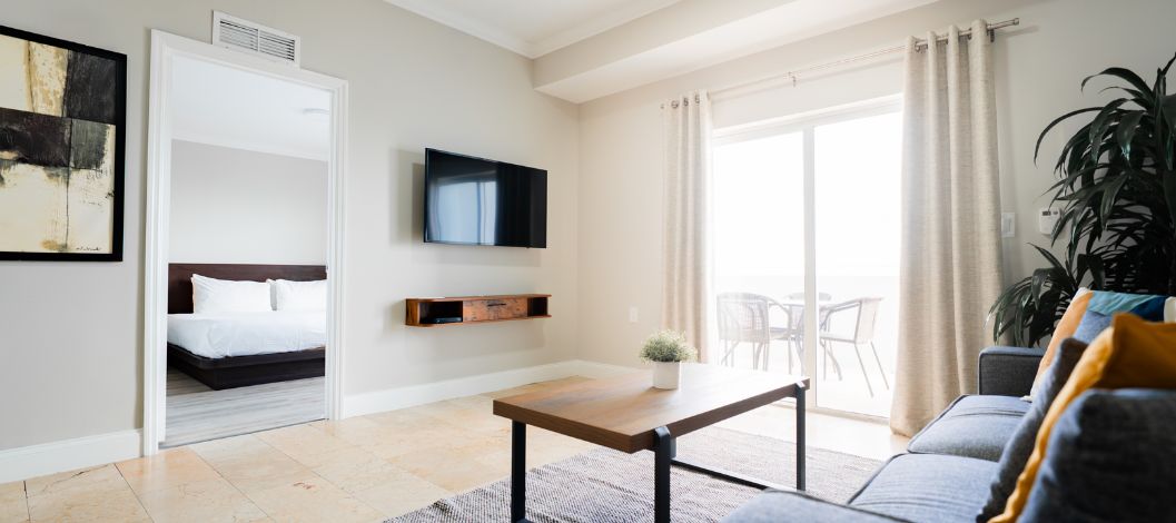 Seating area with sofa and coffee table, view of balcony table and chairs